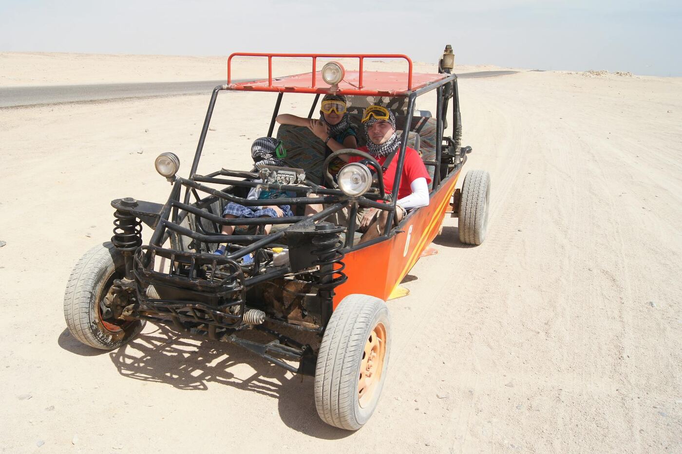 Off-road buggy on a dusty desert track under a bright sun, typical of the volcanic-interior tours out of Costa Teguise