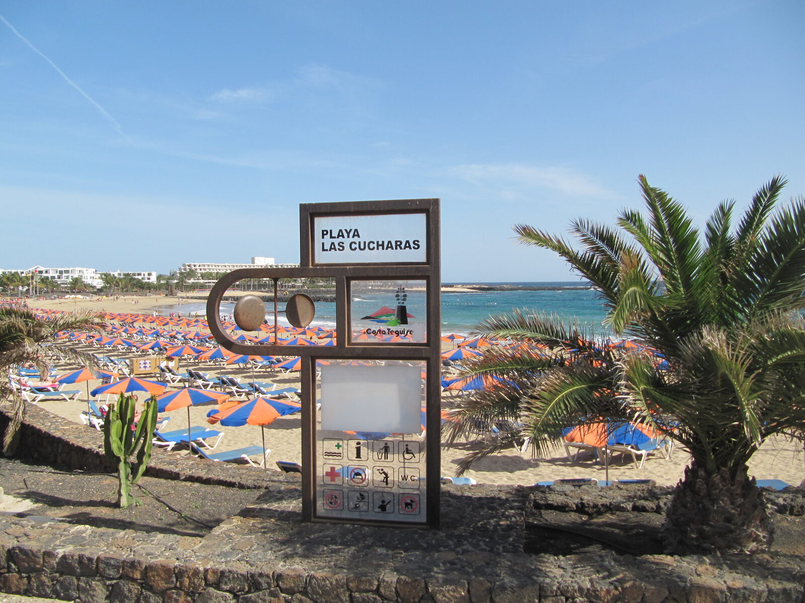 Las Cucharas beach in Costa Teguise, Lanzarote, with windsurfers on the water and dark golden sand