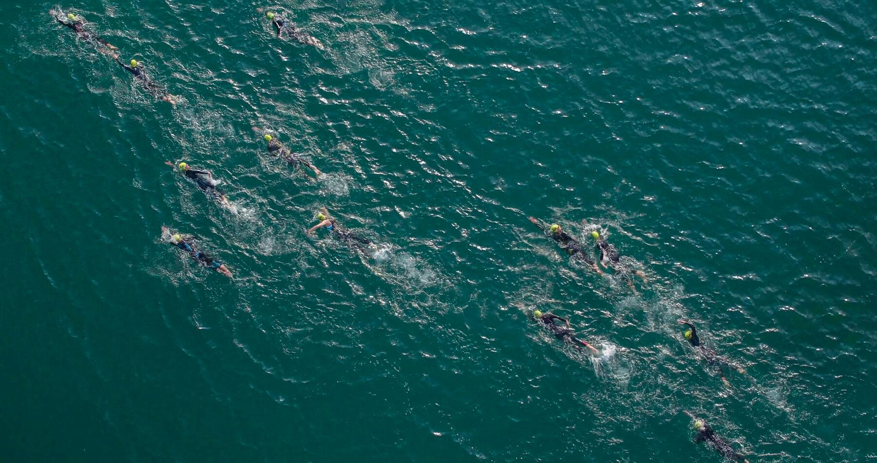 Two open water swimmers front-crawling side by side in the open Atlantic, Lanzarote race day