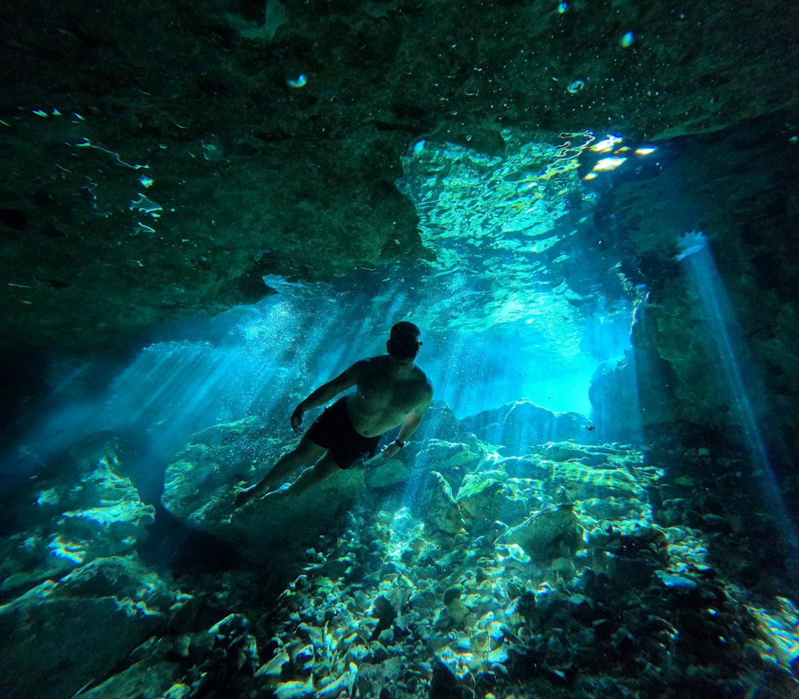 Underwater cave with a diver silhouetted against blue light, reminiscent of The Cathedral at Playa Chica, Lanzarote