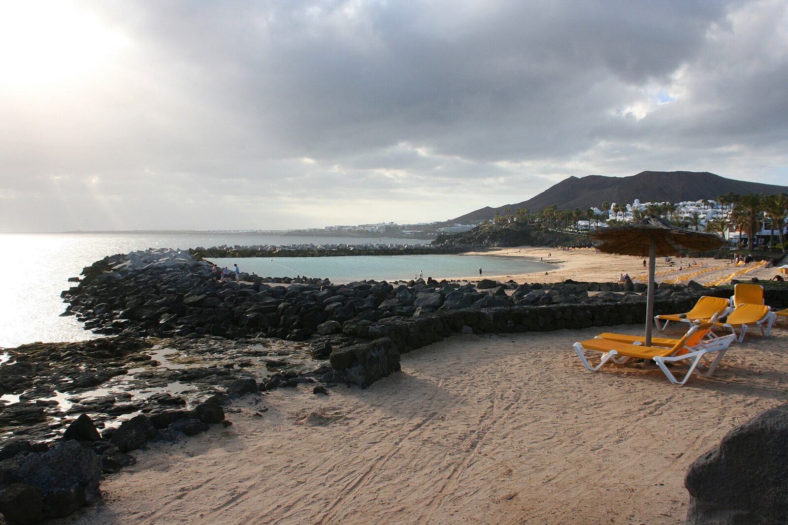 Playa Flamingo in Playa Blanca, Lanzarote, a sheltered horseshoe bay protected by two breakwaters