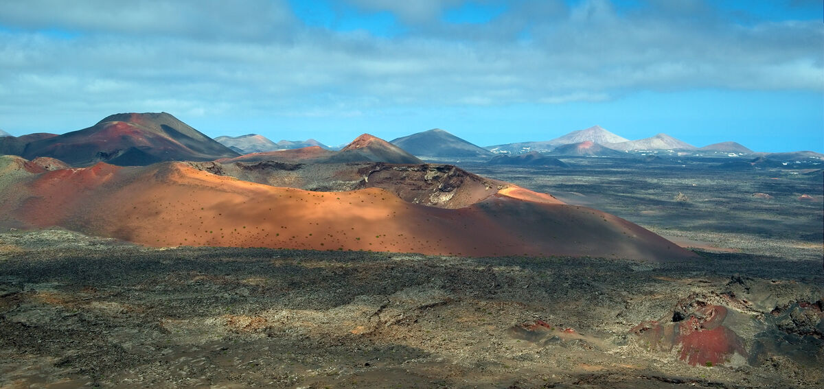 Volcanic landscape of Timanfaya National Park with red and black lava fields in Lanzarote