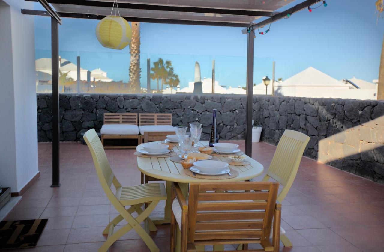 Terrace dining area with volcanic stone walls and palm views
