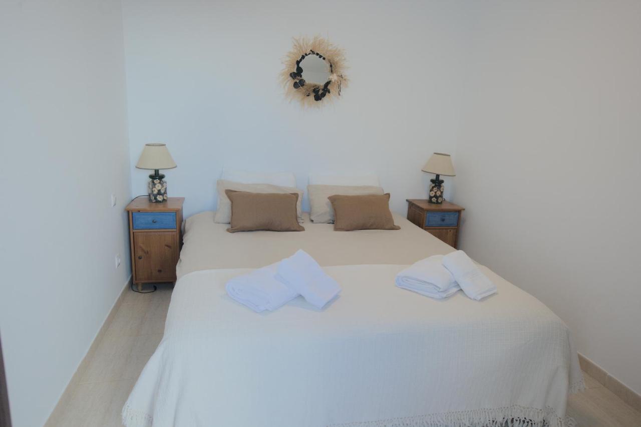 Master bedroom with queen bed, decorative mirror and fresh towels