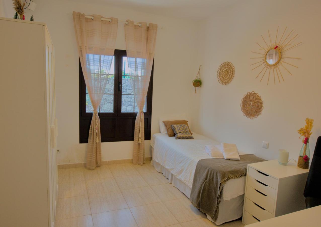 Bright single bedroom with boho wall decor and natural light